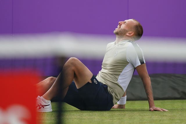 Dan Evans winces in pain after slipping during his match at Queen's 