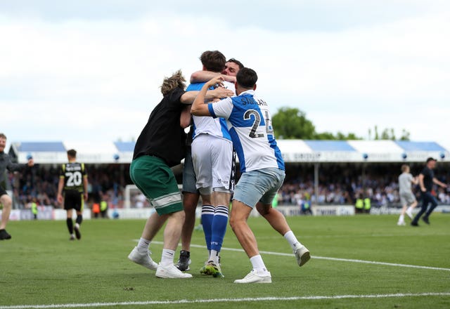 Bristol Rovers fans swarm Anthony Evans following their side's seventh goal