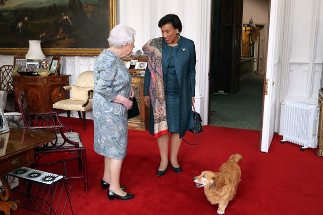 The Queen receives the Commonwealth Secretary-General, Baroness Patricia Scotland, with one of her dogs in attendance (PA)