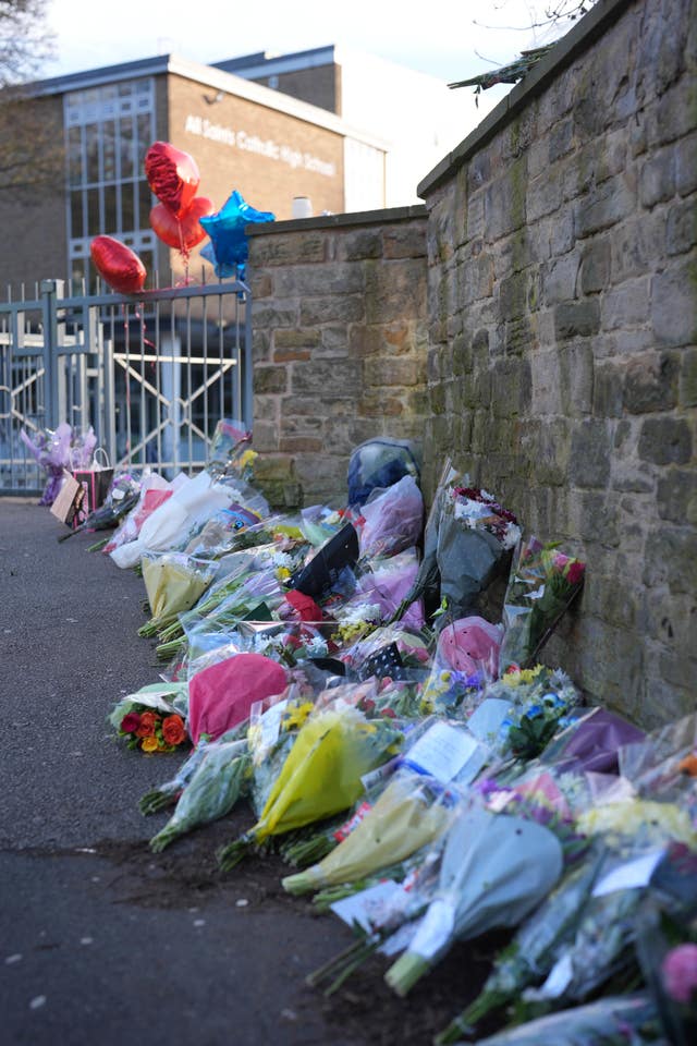 Floral tributes by a wall
