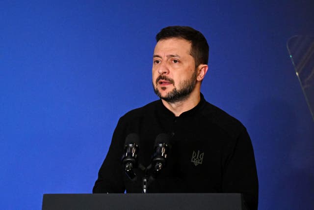 Volodymyr Zelensky speaking at a lectern