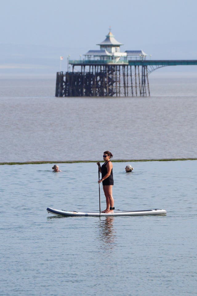 Someone paddleboarding with a pier in the background