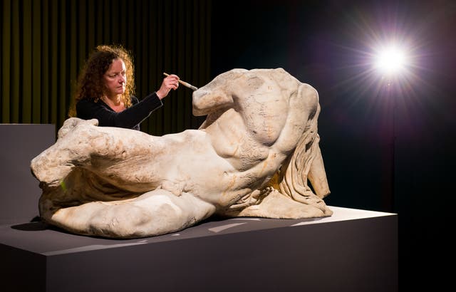 Senior Conservator Karen Birkhoelzer is seen with the sculpture The River God Ilissos by Phidias, part of the part of the Elgin marbles
