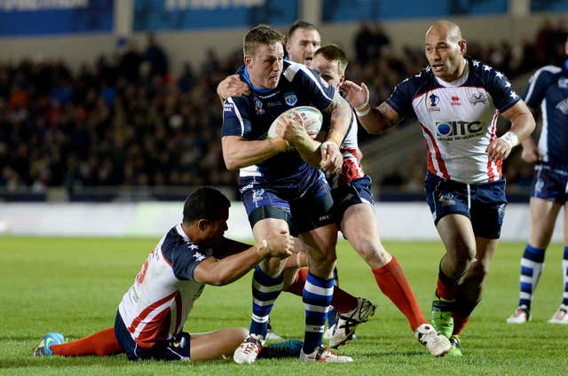 Oliver Wilkes is tackled by USA’s Joseph Paulo 