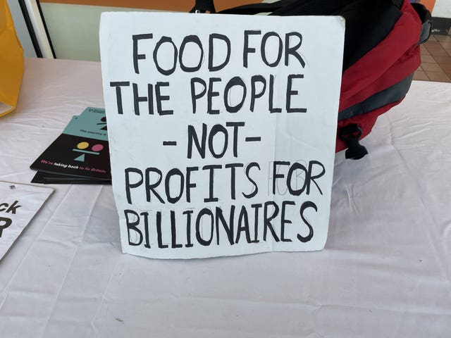 A sign reading 'food for the people - not profits for billionaires'