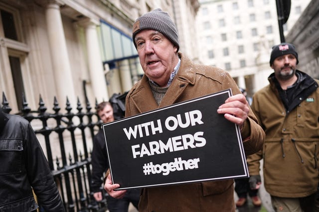 Jeremy Clarkson holding a sign in support of farmers