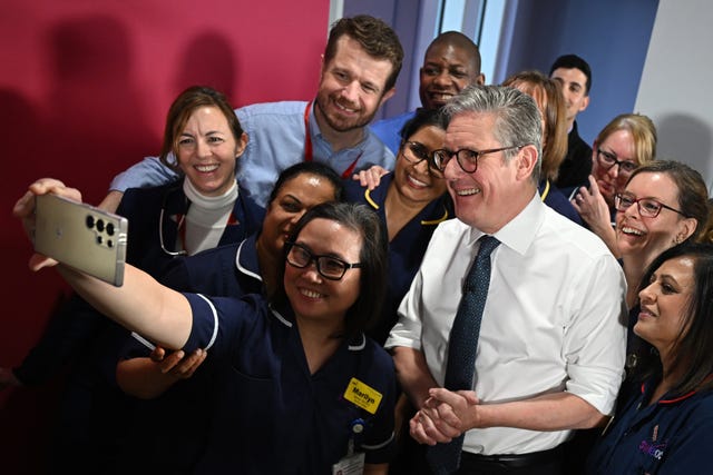 Prime Minister Sir Keir Starmer takes a selfie with members of NHS staff at the end of a visit to the Elective Orthopaedic Centre in Epsom, Surrey