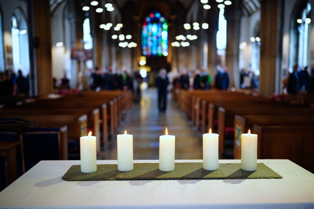 Five lit candles on the altar following a civic service led by the Bishop of Plymouth at Minister Church Of St Andrew, to remember the five people who were killed by Jake Davison