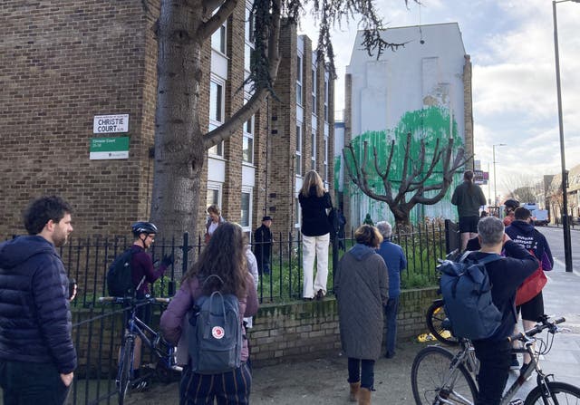 Members of the public look at the new Banksy artwork