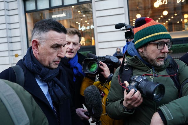 Fujitsu’s European boss Paul Patterson, right, surrounded by media as he leaves the inquiry