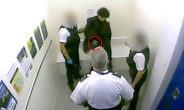 Screen grab taken from CCTV of Louis De Zoysa who is holding an item in his hand before Sergeant Matt Ratana (centre) was shot inside a custody block in Croydon