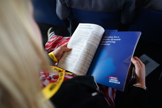 Unidentified person reads the Conservatives' manifesto document