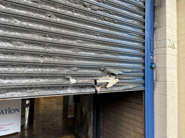 Close-up view of fire damage to metal shutters