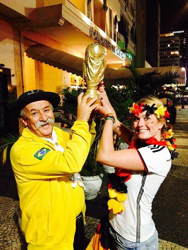 Clovis Acosta Fernandes, also known as Gaucho da Copa, holding a replica World Cup with the German fan he gave the cup to after the 7-1 defeat to Germany in 2014