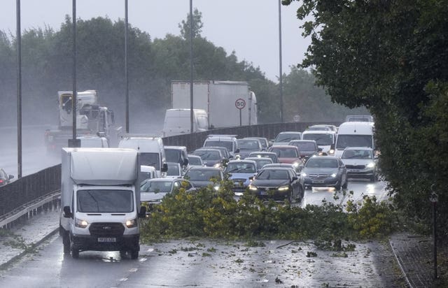 Vehicles negotiate debris from a tree on the North Circular in London