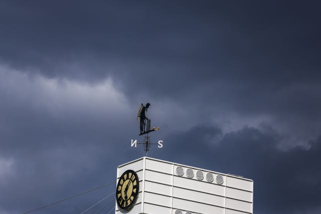 A weather vane before dark clouds