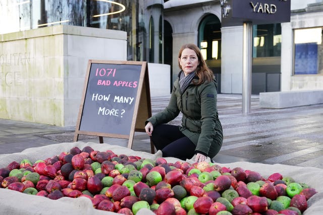 Refuge chief executive Ruth Davison helps place 1,071 rotten apples outside New Scotland Yard, reflecting the number of Metropolitan Police officers who have been, or are currently, under investigation for allegations of domestic abuse or violence against women and girls