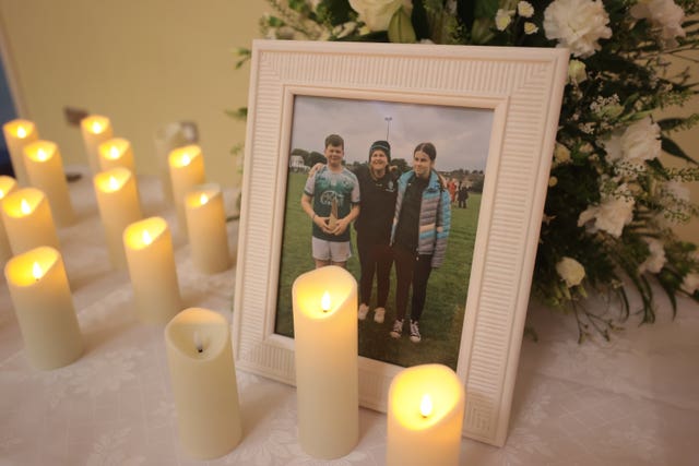 Candles surround a photograph of shooting victims Vanessa Whyte, 45 and her children, James, 14, and Sara, 13 