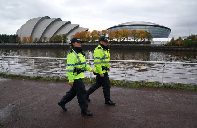 Police officers walk along the banks of the River Clyde by the Scottish Event Campus in Glasgow where Cop26 is being held (Andrew Milligan/PA)