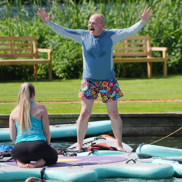 Liberal Democrat leader Sir Ed Davey stands on an inflatable on water