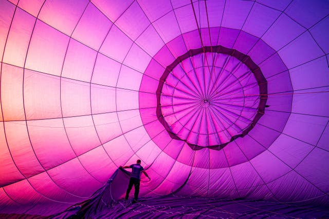 A balloon pilot checks the rigging during pre-flight inflation checks