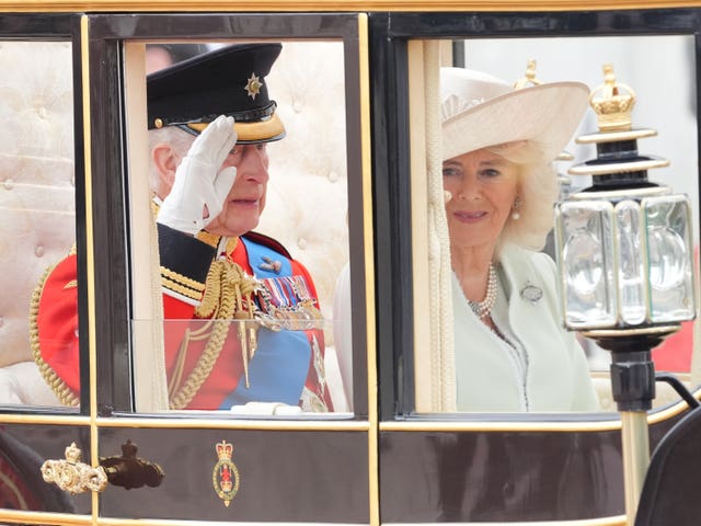 The King and Queen wave to onlookers as they travel along The Mall to the Trooping the Colour ceremony at Horse Guards Parade