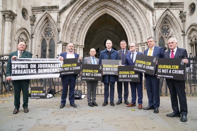 Group of people outside the Royal Courts of Justice holding a banner