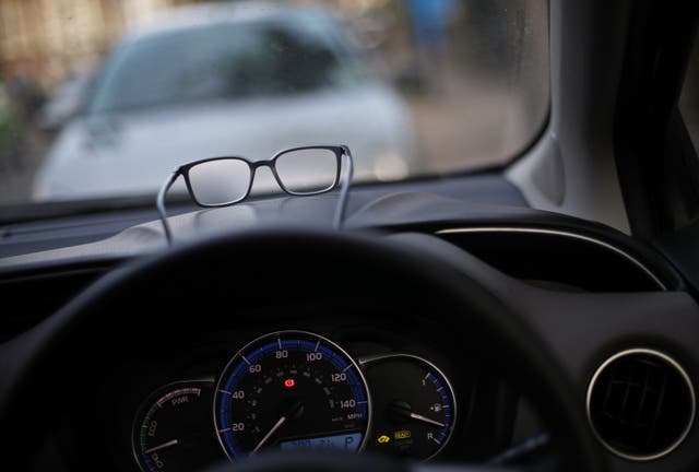 A pair of glasses resting on the dashboard of a car