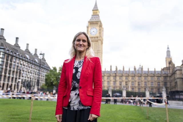 A woman in a red jacket outside Parliament