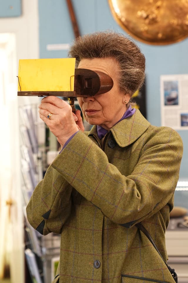 The Princess Royal looking at photos using a stereoscopic viewer during a visit to  the Sark Society