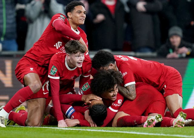 Liverpool’s Virgil van Dijk (on the floor) is congratulated by his team mates after scoring the winning goal