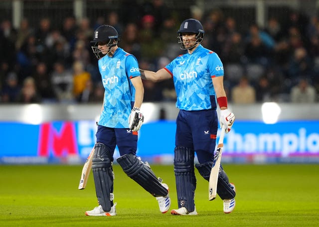 Harry Brook, left, is patted on the back by Liam Livingstone as England's batters leave the pitch for rain