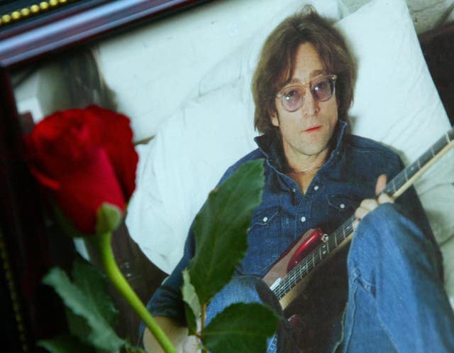 A single red rose is placed next to a photograph of late Beatle John Lennon