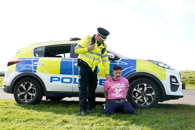 A protester is detained by police