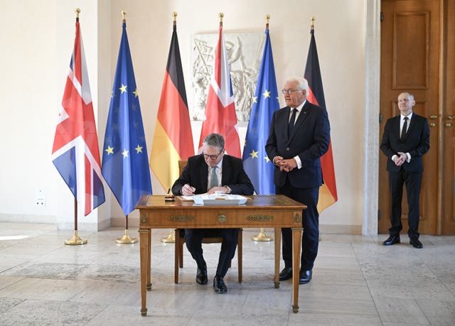 German President Frank-Walter Steinmeier looks on as Prime Minister Keir Starmer (left) signs a guest book at Bellevue Palace 