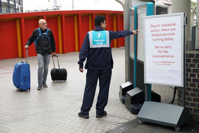 A station worker assists a passenger at Paddington Station in London, as train services continue to be disrupted following the nationwide strike by members of the Rail, Maritime and Transport union along with London Underground workers in a bitter dispute over pay, jobs and conditions 