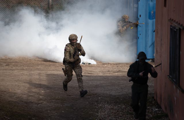 Royal Marine Commandos storm a compound during a live exercise demonstration at Bovington Camp in Dorset to showcases core equipment capabilities highlighted in Monday's defence command paper