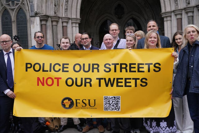 People holding a banner saying 'Police our streets not our tweets'