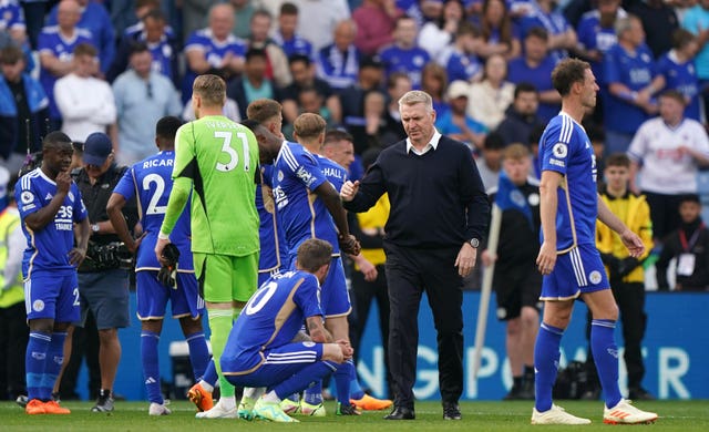 Leicester manager Dean Smith consoles his players after their relegation
