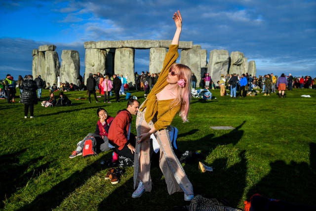 A woman performs yoga at Stonehenge