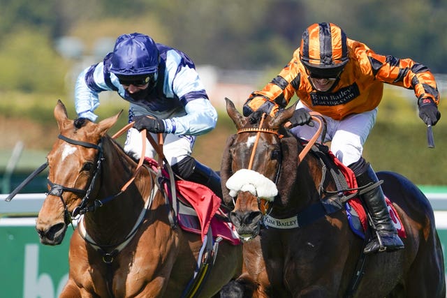 David Bass riding Younevercall (orange) on their way to winning the bet365 Select Hurdle at Sandown