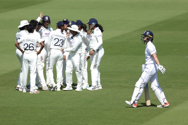 England's Amy Jones, right, leaves the pitch as India players celebrate her wicket