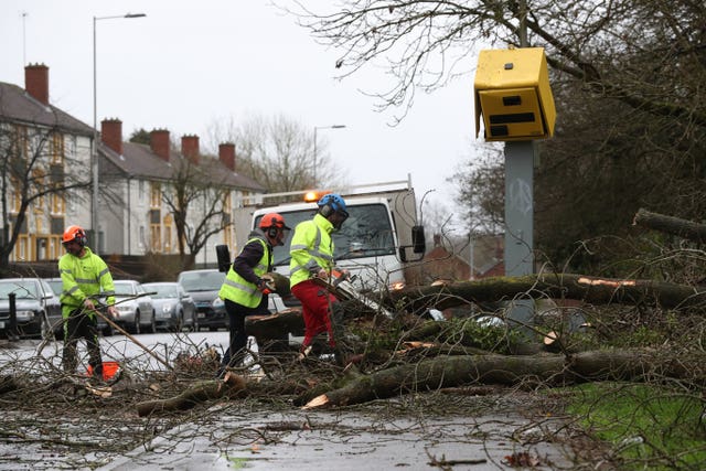 Workmen clear up after a tree fell on a speed camera on the Meadway in Tilehurst, Reading 
