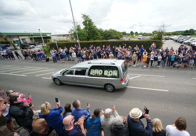 Crowds watch the funeral cortege of former Leeds Rhinos player Rob Burrow