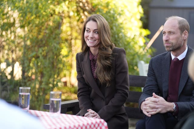 Kate smiles as she sits next to William during a visit to Southport in October