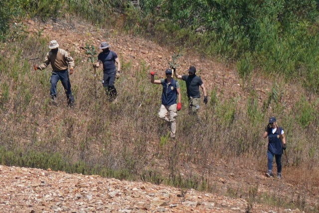 Search team scouring grass and scrubland