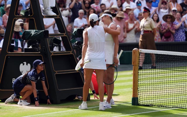 Iga Swiatek consoles Amanda Anisimova at the net