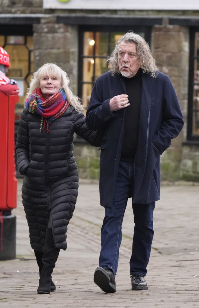 A female with her arm linked with Robert Plant