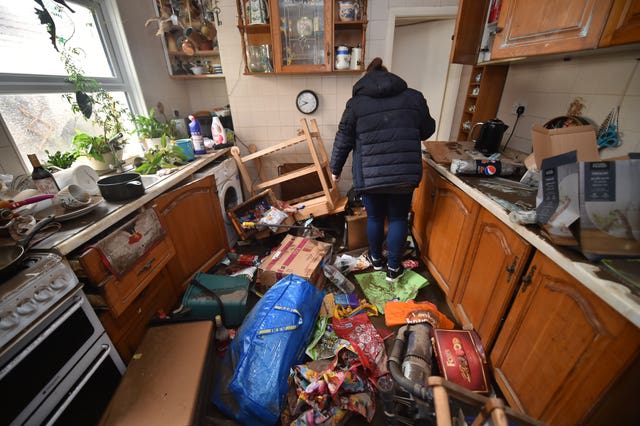 Rachel Cox inspecting flood damage in her kitchen in Nantgarw (Ben Birchall/PA).