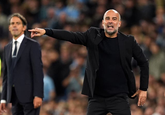 Pep Guardiola points on the touchline during a match